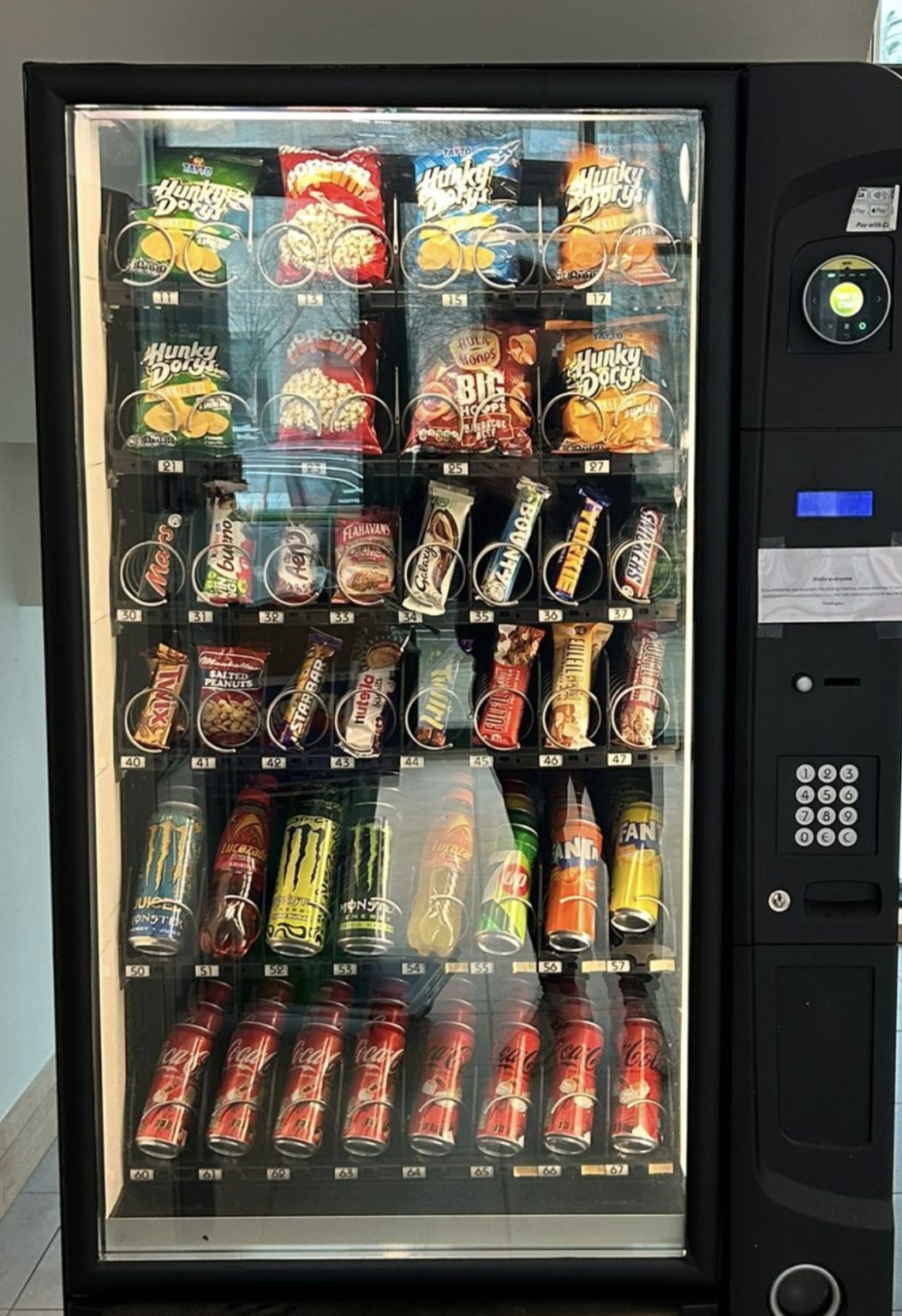 Fully stocked vending machine with crisps, chocolate, cold drinks and energy drinks