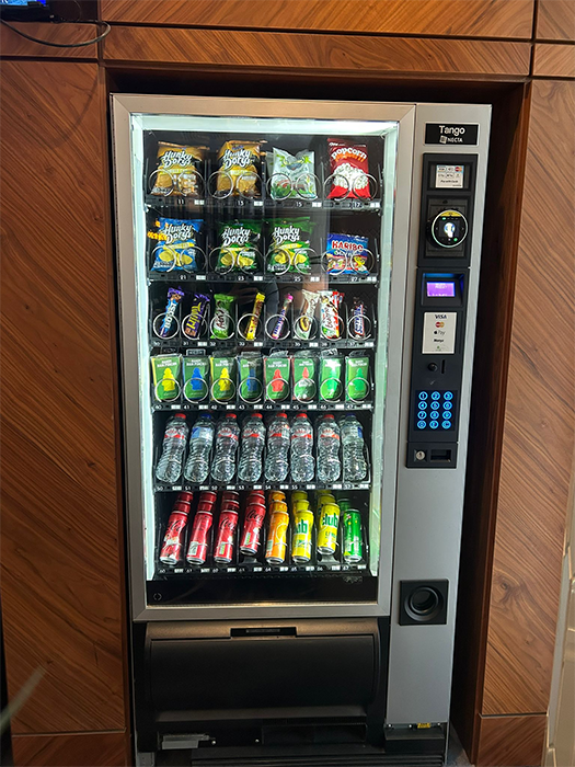 Glass-front vending machine stocked with branded snacks and drinks