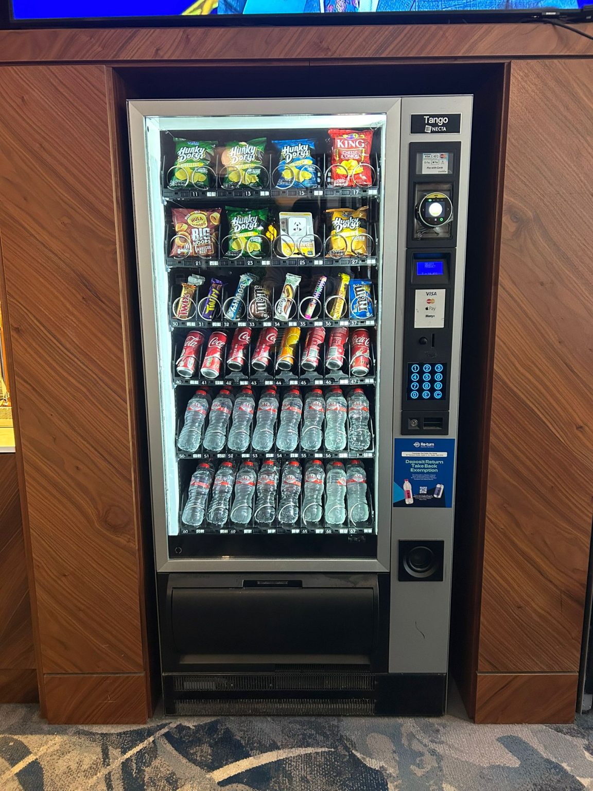 Vending machine installed in a walnut-panelled hotel breakout area